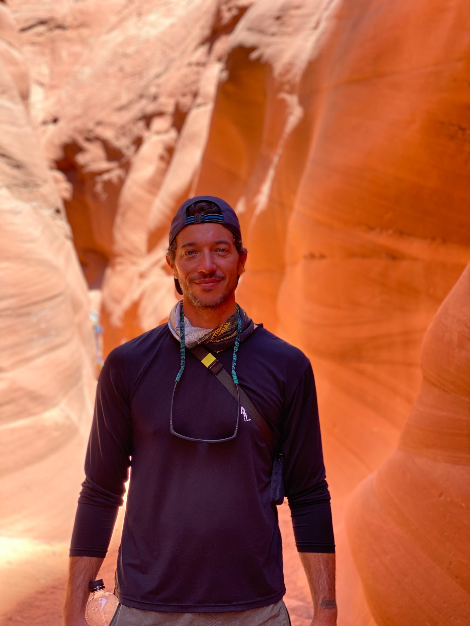 Coach standing in a canyon wearing athletic apparel.
